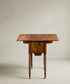 Mesa costurero antigua de caoba estilo Regencia con patas anilladas y ruedas.