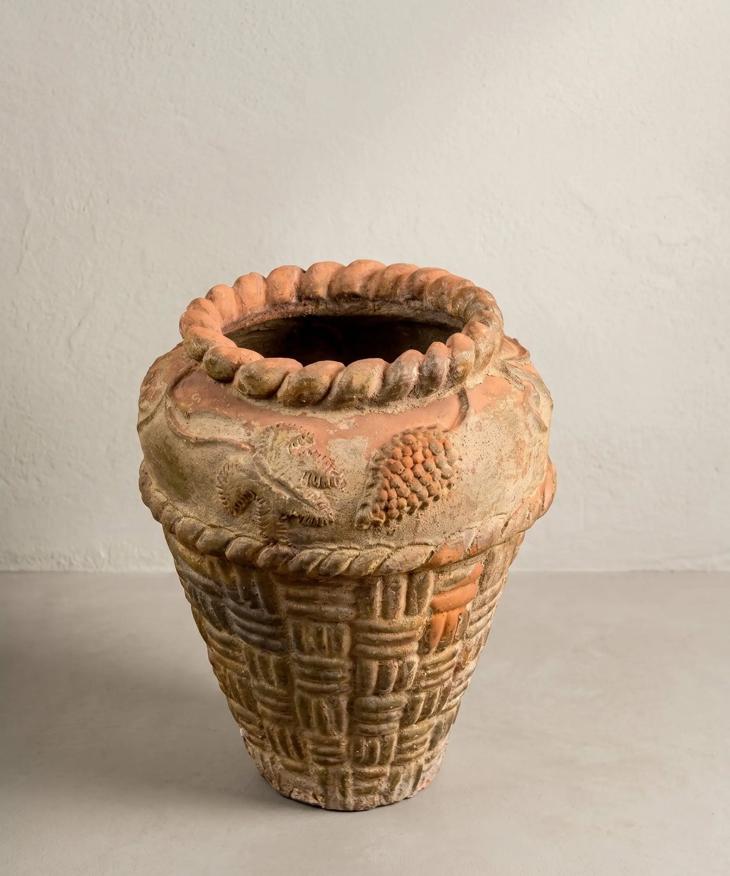 Macetero antiguo de terracota con relieve de cestería y motivos florales