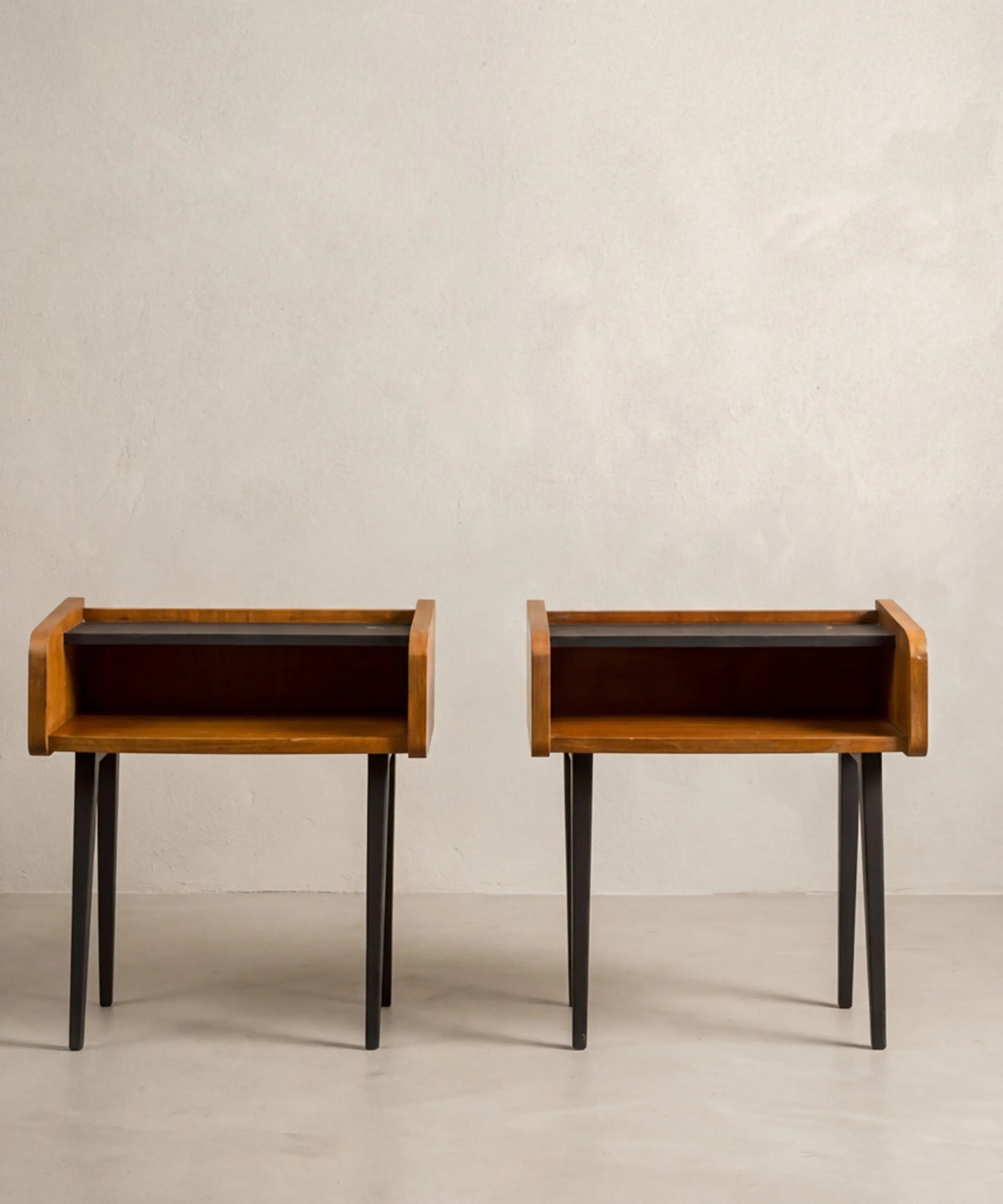 Pareja de mesitas de noche vintage Mid-Century de madera de teca y patas negras anguladas.