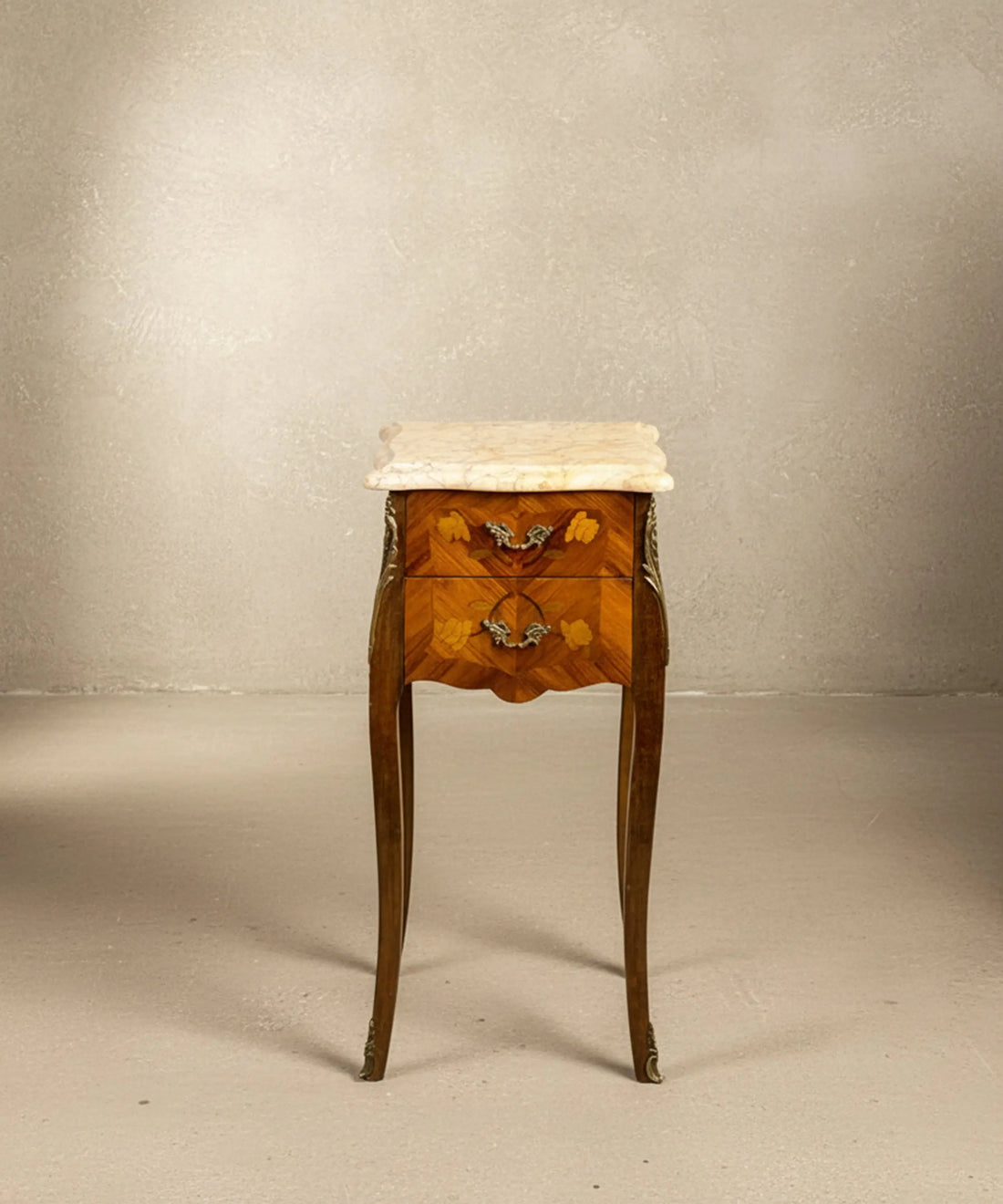 Mesita auxiliar vintage estilo Luis XV con patas altas, marquetería y mármol beige.
