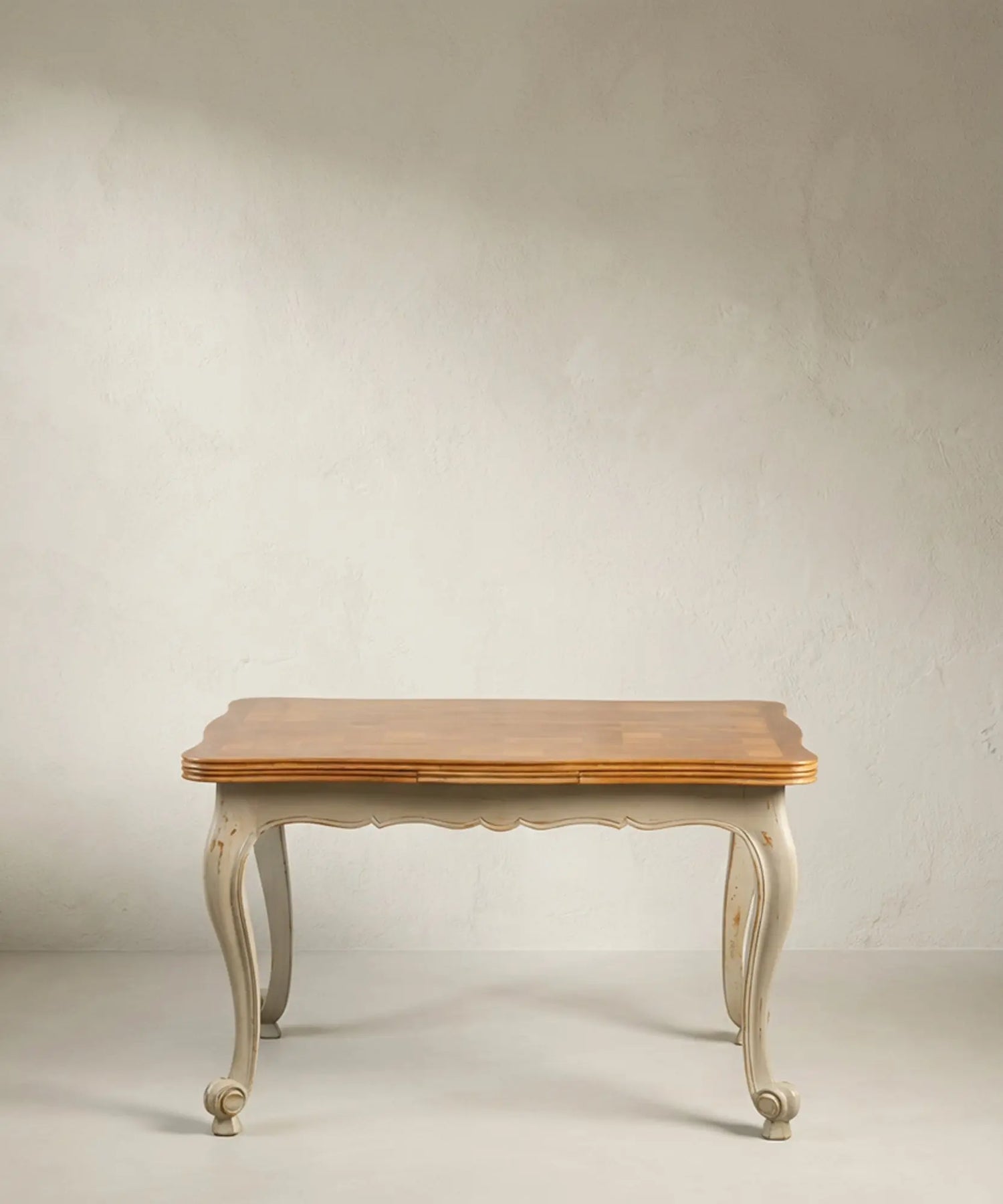 Mesa de comedor vintage estilo francés bicolor con patas curvas grises y tapa de madera.