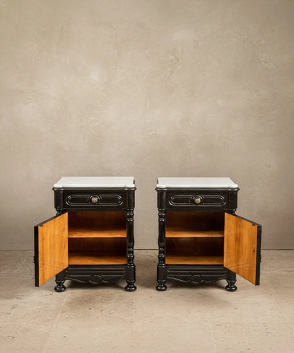 Mesitas de noche antiguas con cajones y puertas abiertas mostrando el interior de madera natural y herrajes de latón.