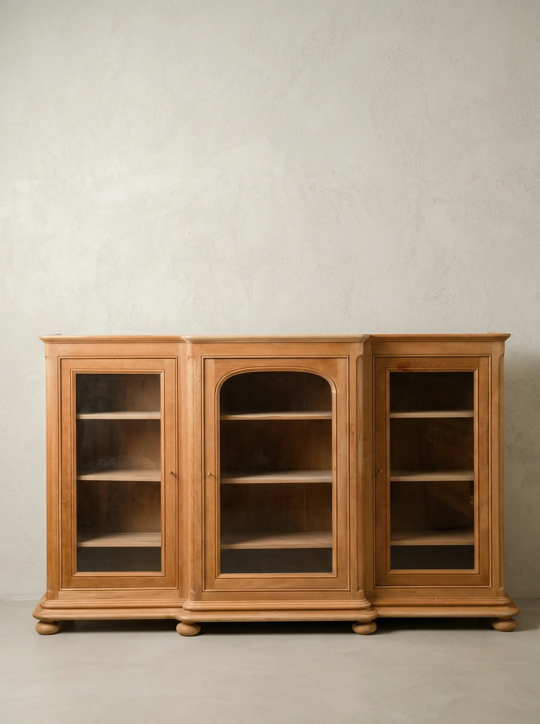 Vitrina aparador de tres cuerpos en madera de cerezo vista frontal sobre fondo neutro.