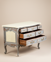 Cómoda estilo Luis XV con sus seis cajones abiertos, mostrando el interior de madera natural.