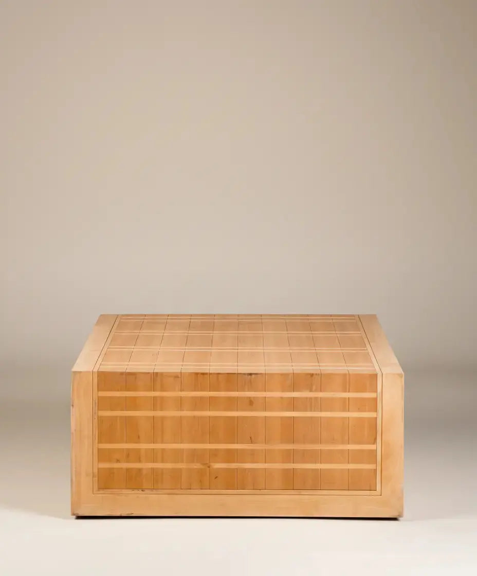  Mesa de centro cuadrada de madera clara con diseño de rejilla, vista frontal sobre fondo neutro.
