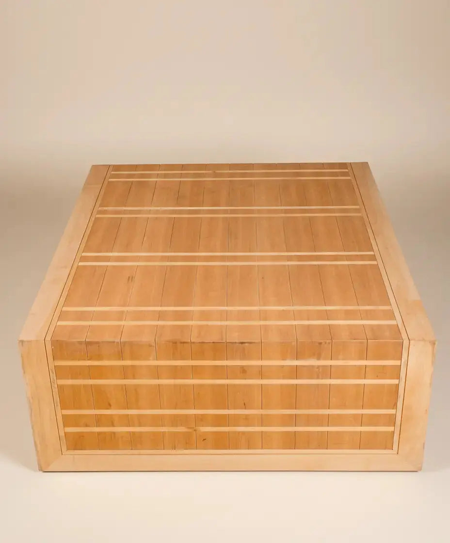 Mesa de centro artesanal de madera vista desde un ángulo superior, destacando el patrón geométrico
