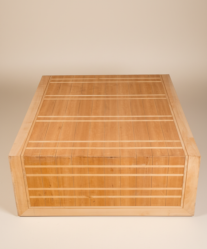 Mesa de centro artesanal de madera vista desde un ángulo superior, destacando el patrón geométrico