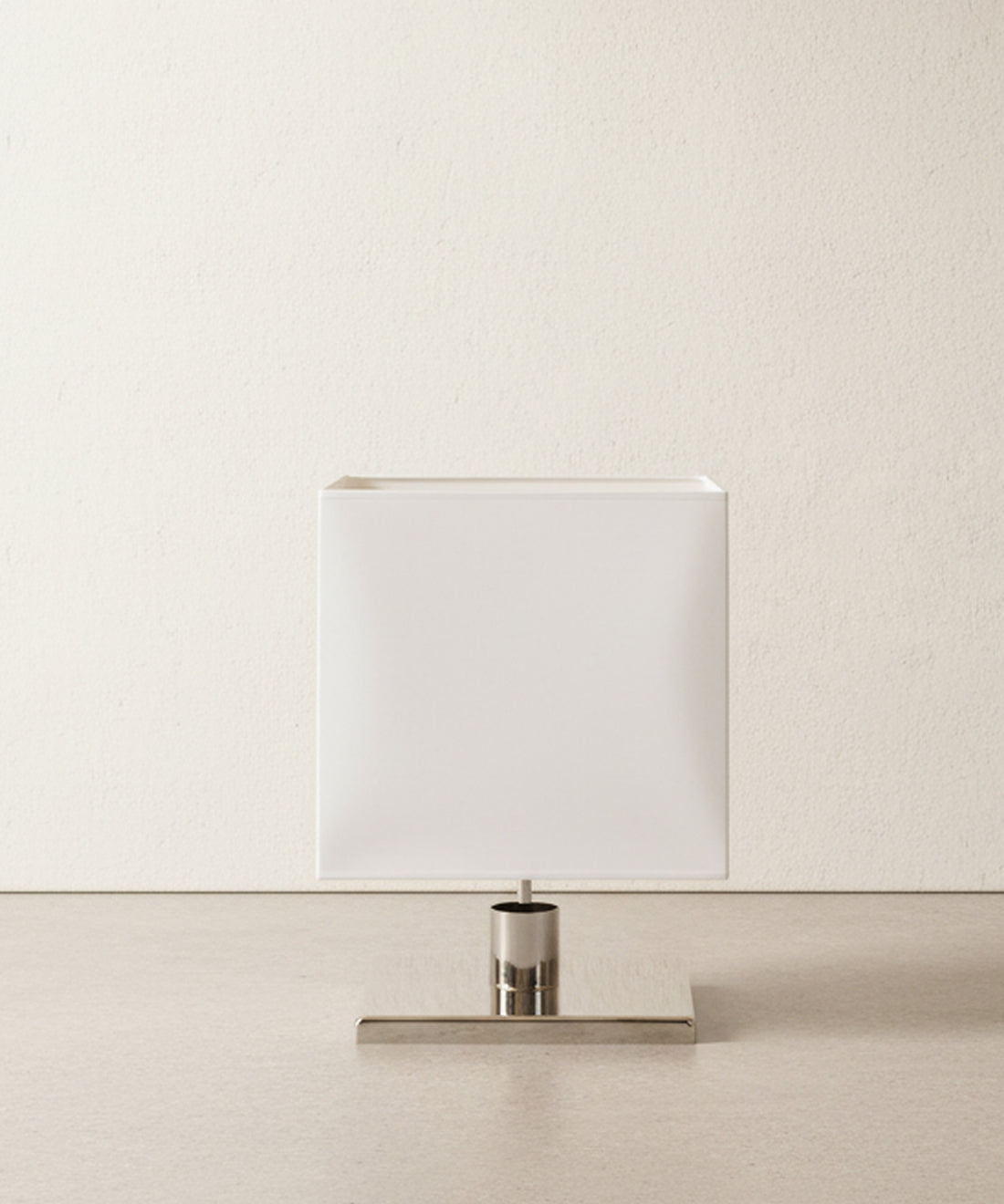 Lámpara de sobremesa de diseño minimalista con pantalla cúbica blanca y base de cromo pulido vista frontal.