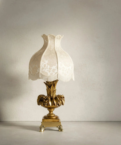 Gran lámpara de sobremesa vintage de madera dorada con patas de garra y pantalla pagoda de flecos.