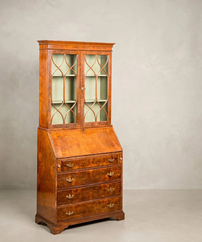 Vista frontal completa del bureau-bookcase inglés antiguo en raíz de nogal, con la vitrina cerrada y el escritorio cerrado.