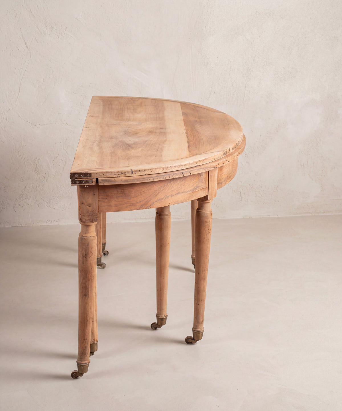 Consola demi-lune antigua vista de perfil con bisagras de hierro y ruedas — Antique Arte y Decoración