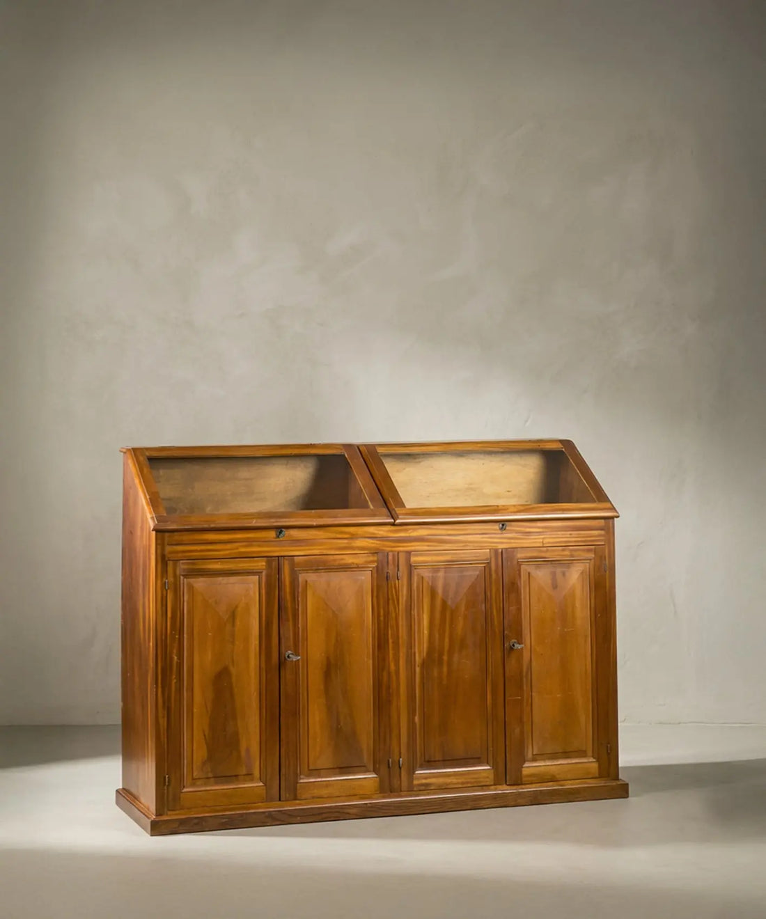 Vista lateral del mostrador vintage destacando la inclinación de la vitrina superior de cristal.