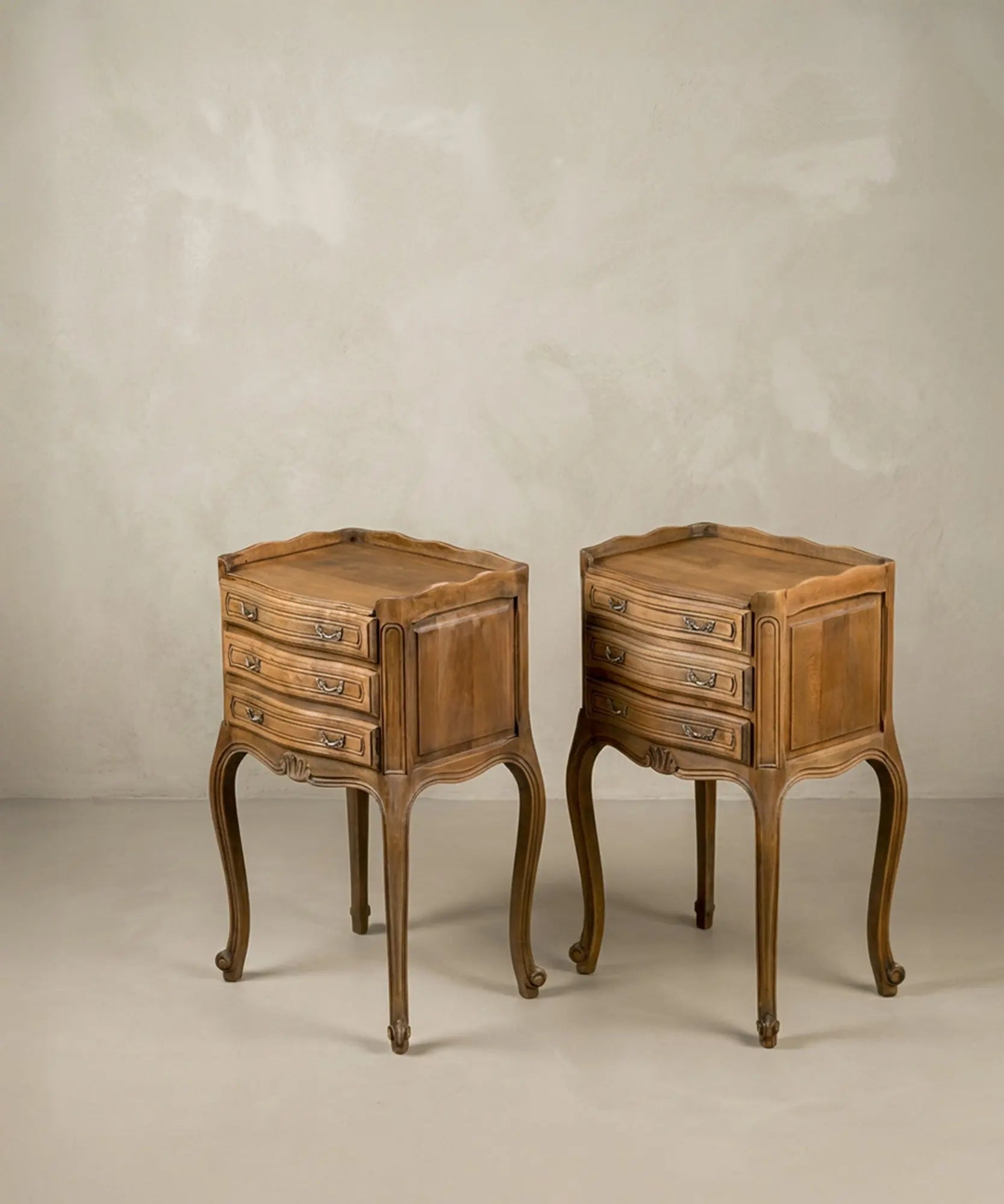 Vista lateral de las mesitas resaltando la curvatura de las patas cabriolé y el diseño bombée.