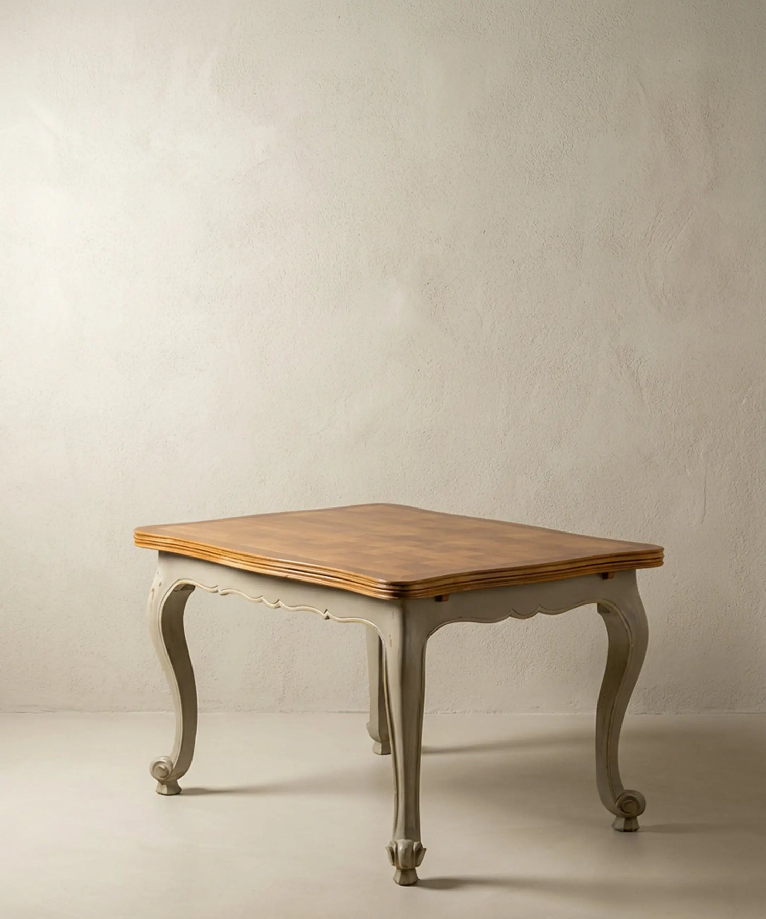 Mesa de comedor vintage estilo francés bicolor con patas curvas grises y tapa de madera.