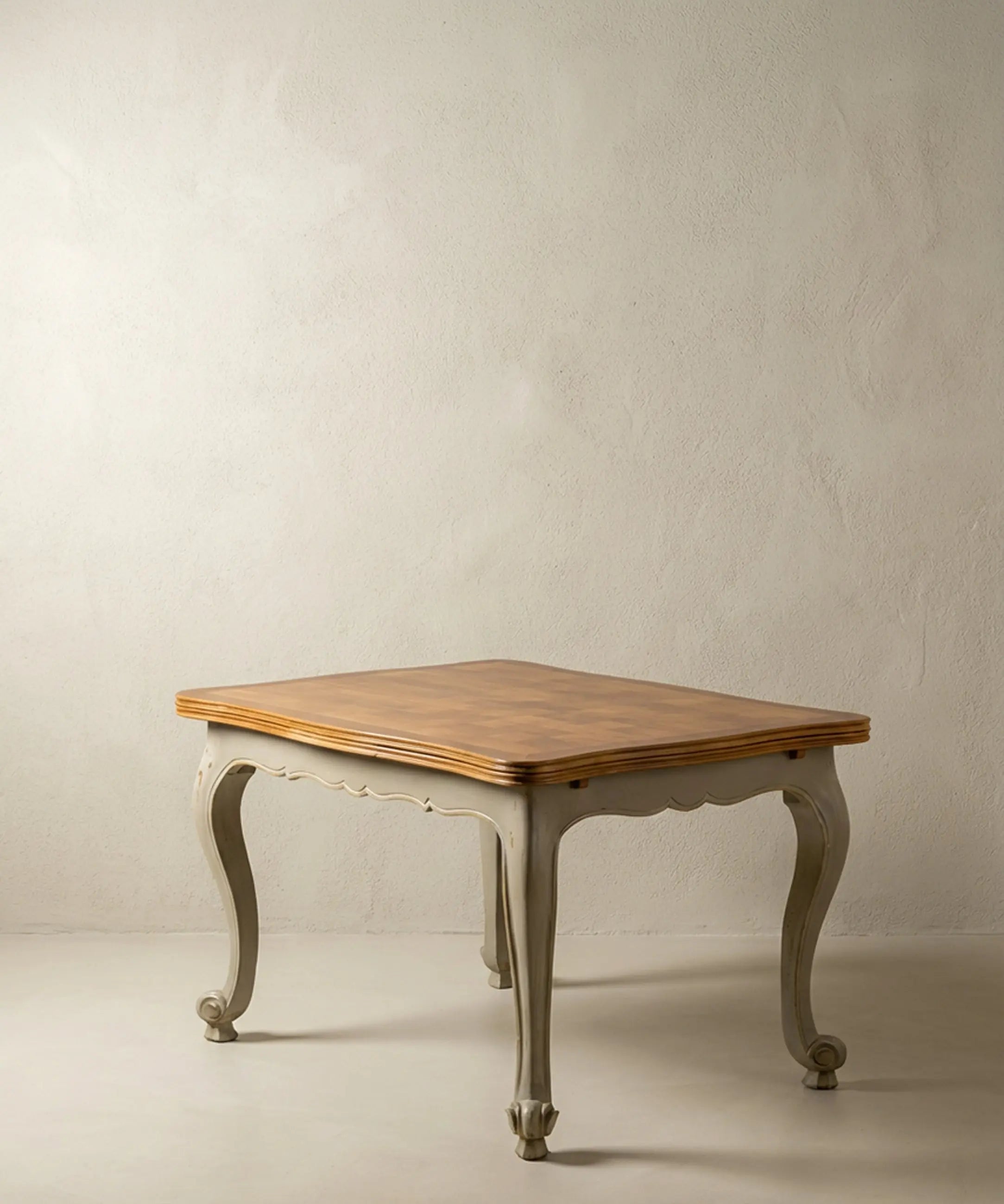 Mesa de comedor vintage estilo francés bicolor con patas curvas grises y tapa de madera.