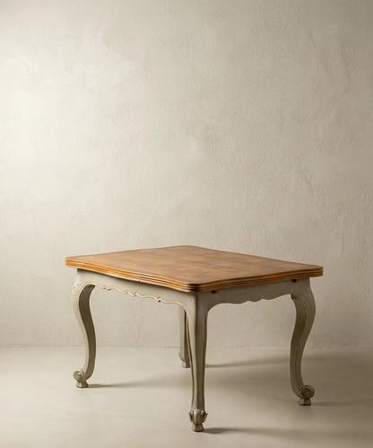 Mesa de comedor vintage estilo francés bicolor con patas curvas grises y tapa de madera.