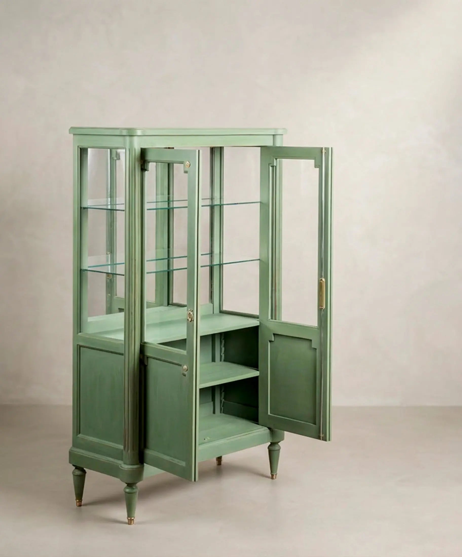 Vitrina verde abierta en tres cuartos mostrando las baldas de cristal y el interior — Antique Arte y Decoración