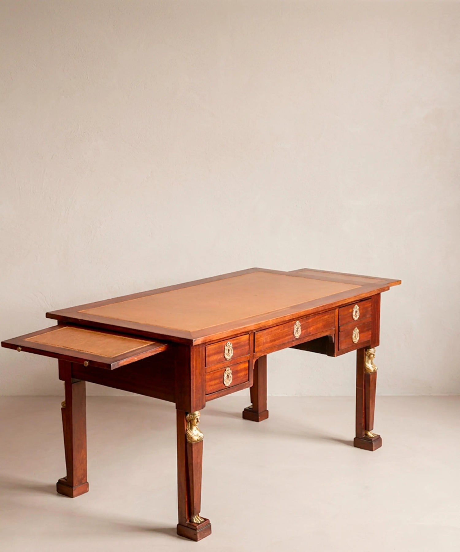 Escritorio de centro antiguo de caoba con alas laterales extraíbles abiertas y tablero de cuero cámel.