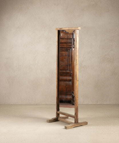 Espejo de pie de madera maciza estilo wabi-sabi reflejando muebles antiguos.