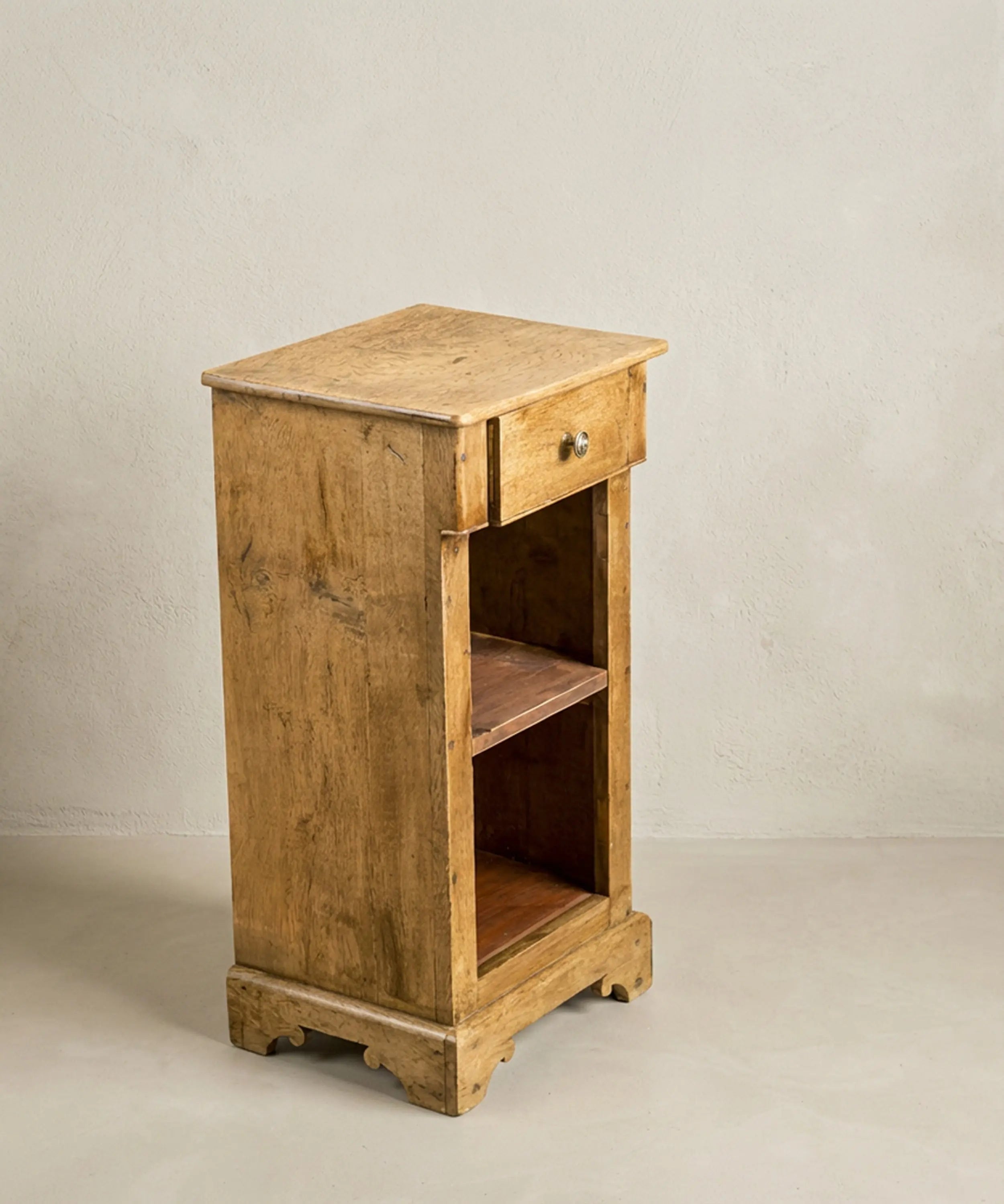 vista lateral mesilla de noche antigua de madera maciza con estantes y cajón estilo rústico francés.