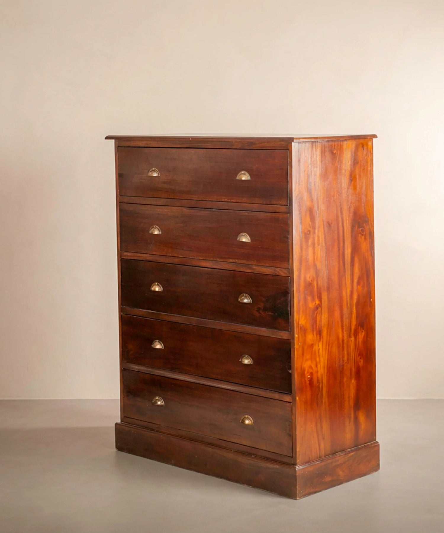 Vista lateral de cajonera alta antigua mostrando el veteado de la madera maciza.