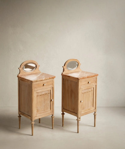 Vista lateral de mesillas de alcoba clásicas decapadas con patas torneadas y tiradores de porcelana.