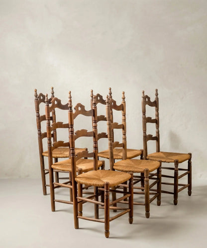 Perspectiva lateral de seis sillas de comedor estilo country chic con respaldo de escalera.