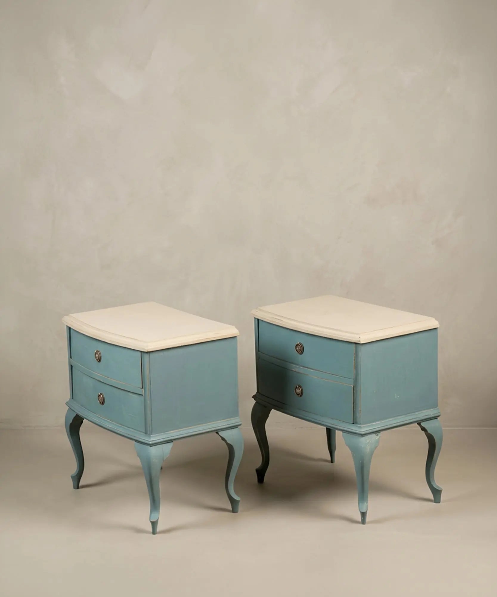 Dos mesillas auxiliares clásicas azules con patas curvas cabriolé y tapa clara.