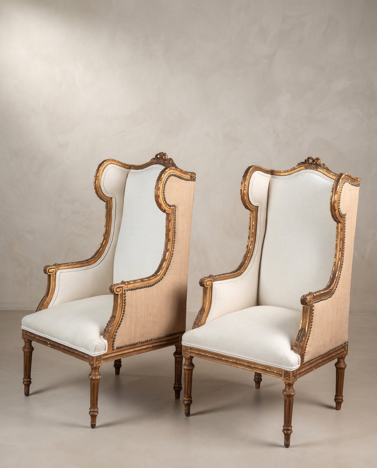 Pareja de sillones orejeros antiguos dorados vista lateral con patas acanaladas — Antique Arte y Decoración