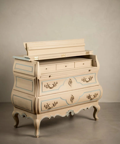 : Cómoda secreter vintage abierta mostrando su interior de escritorio con cajoncitos y tapete de cuero.