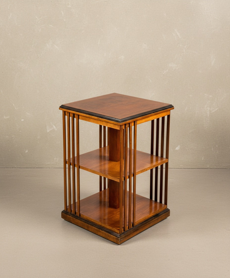 Vista en ángulo de la librería de madera resaltando su profundidad y acabado barnizado satinado.