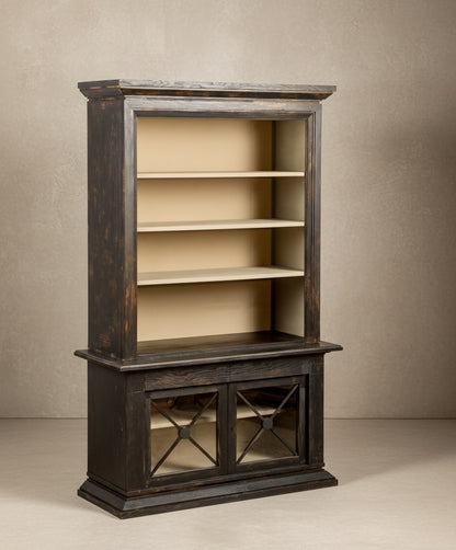 Vista lateral del mueble vitrina mostrando la cornisa superior tallada y la profundidad de los estantes.