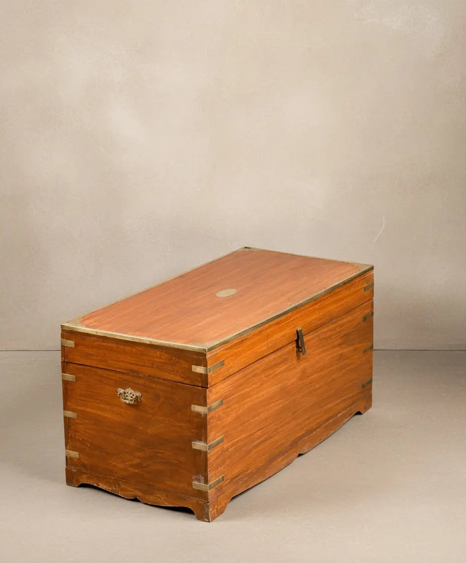 vista lateral Baúl de campaña británico en madera de caoba cerrada, vista frontal mostrando herrajes de latón y veta natural.