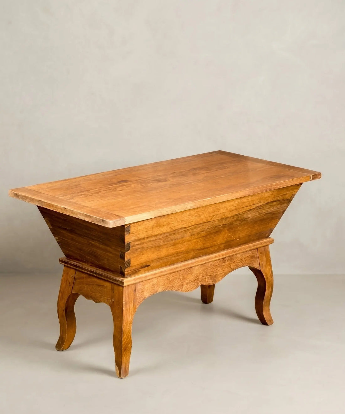 Mesa antigua tipo artesa de madera maciza con patas curvas y tapa plana estilo rústico.