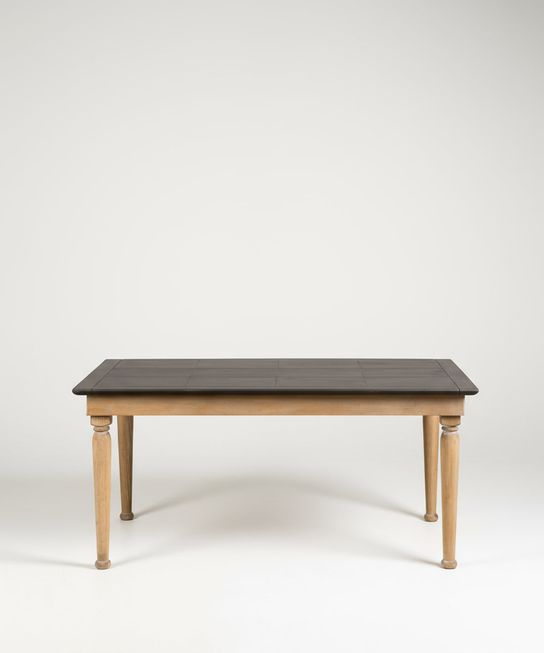 Mesa de comedor rectangular de estilo rústico con patas de madera natural y superficie oscura, fotografiada de frente en un estudio con fondo blanco.