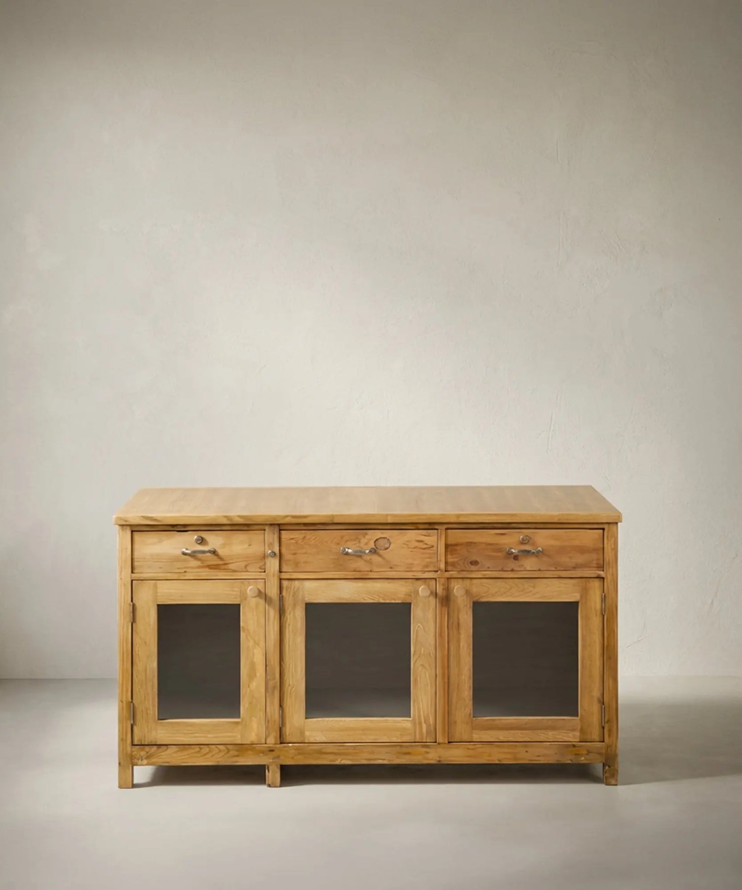Aparador mostrador vintage estilo industrial con puertas de cristal y madera natural lavada.