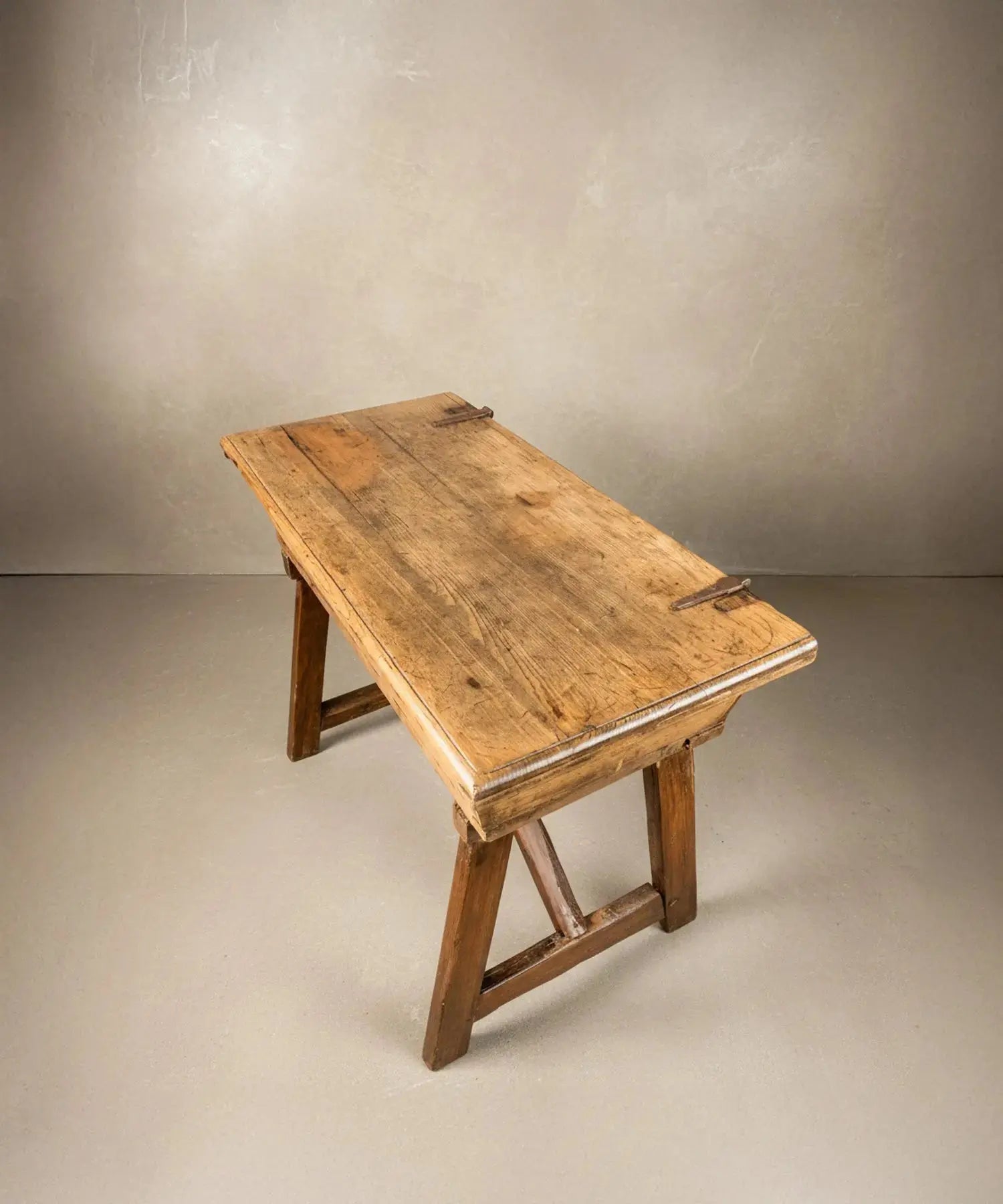 vista superior Mesa artesa antigua de madera maciza con tapa cerrada sobre fondo neutro, estilo rústico.