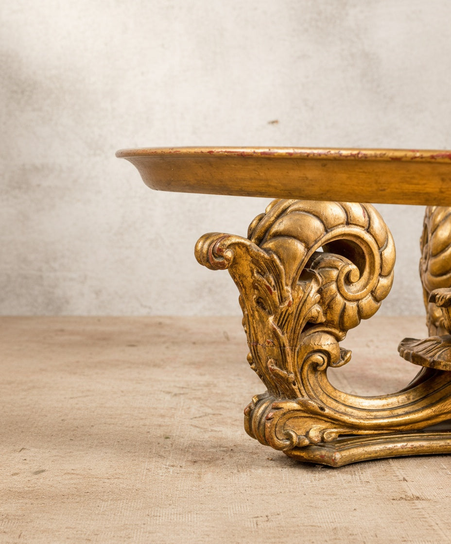 Primer plano de la talla artesanal de las volutas y el acabado envejecido en pan de oro.