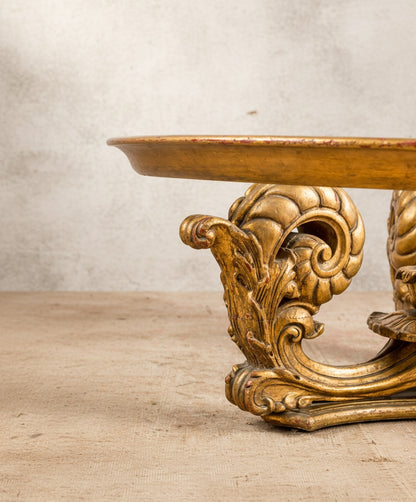 Primer plano de la talla artesanal de las volutas y el acabado envejecido en pan de oro.