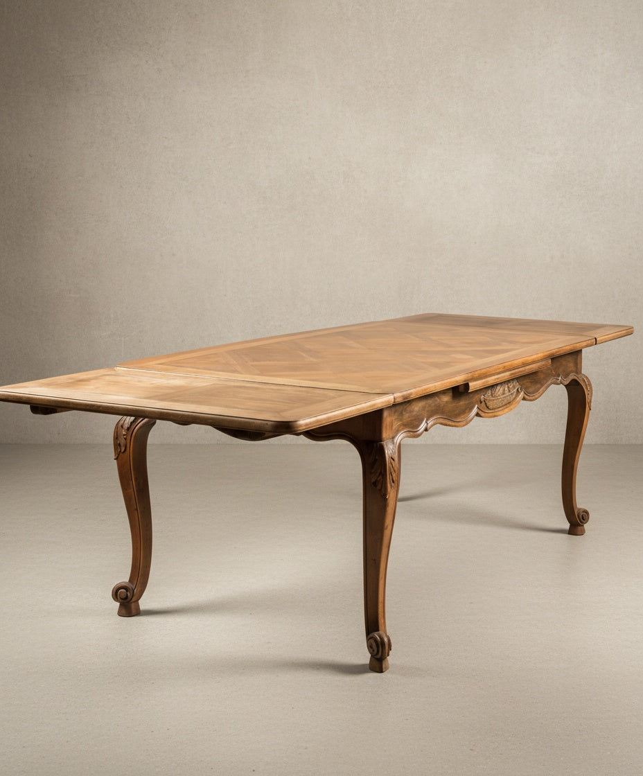 Mesa de comedor Luis XV con alas extensibles abiertas mostrando la versatilidad del tablero.