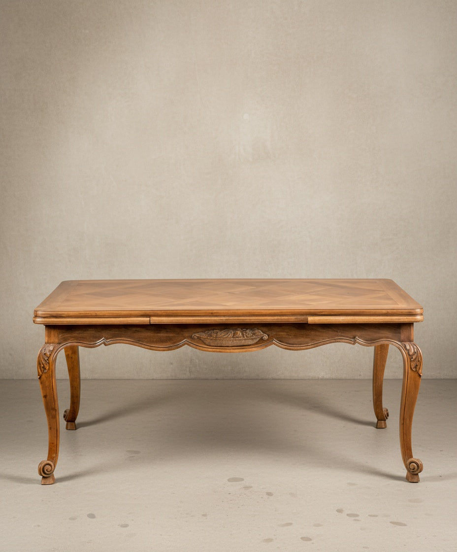  Vista frontal de mesa de comedor francesa con faldón tallado y diseño simétrico.