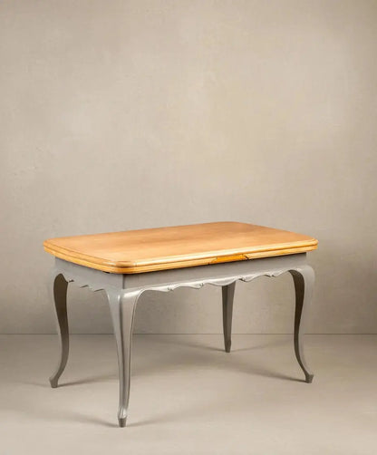 Mesa de comedor vintage bicolor con tablero de madera natural y estructura gris, patas curvas.