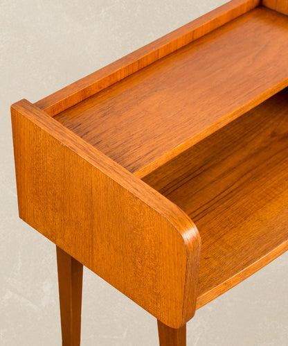 Primer plano de la veta de madera de teca y acabado artesanal de las mesitas escandinavas años 60.