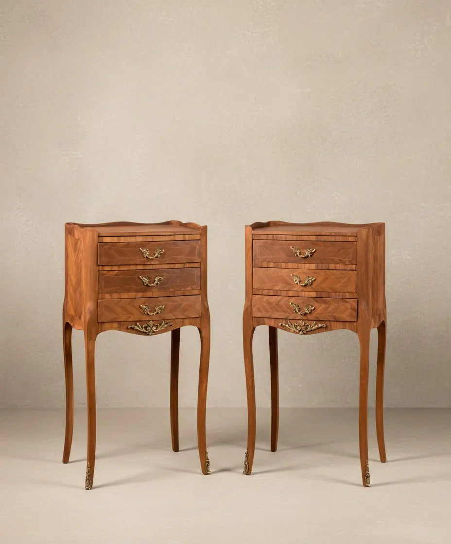 Vista frontal de pareja de mesitas de noche francesas estilo Luis XV en madera con tres cajones y patas altas.