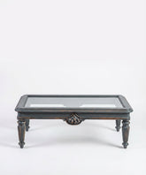 Vista frontal simétrica de la mesa de centro mostrando la estructura de madera y cristal