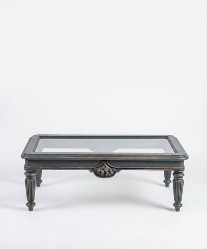 Vista frontal simétrica de la mesa de centro mostrando la estructura de madera y cristal