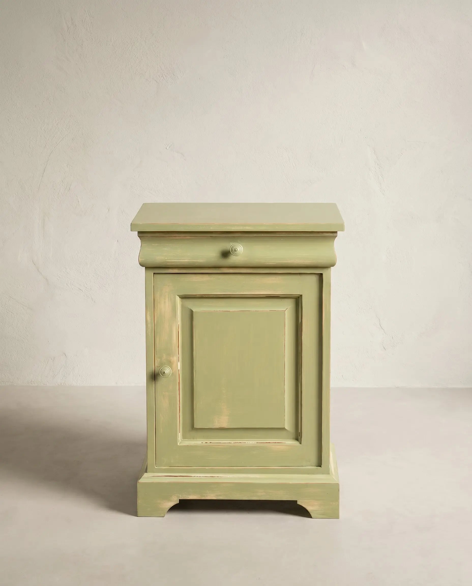 Mesita de noche vintage de madera pintada en verde salvia con acabado decapado estilo shabby chic.