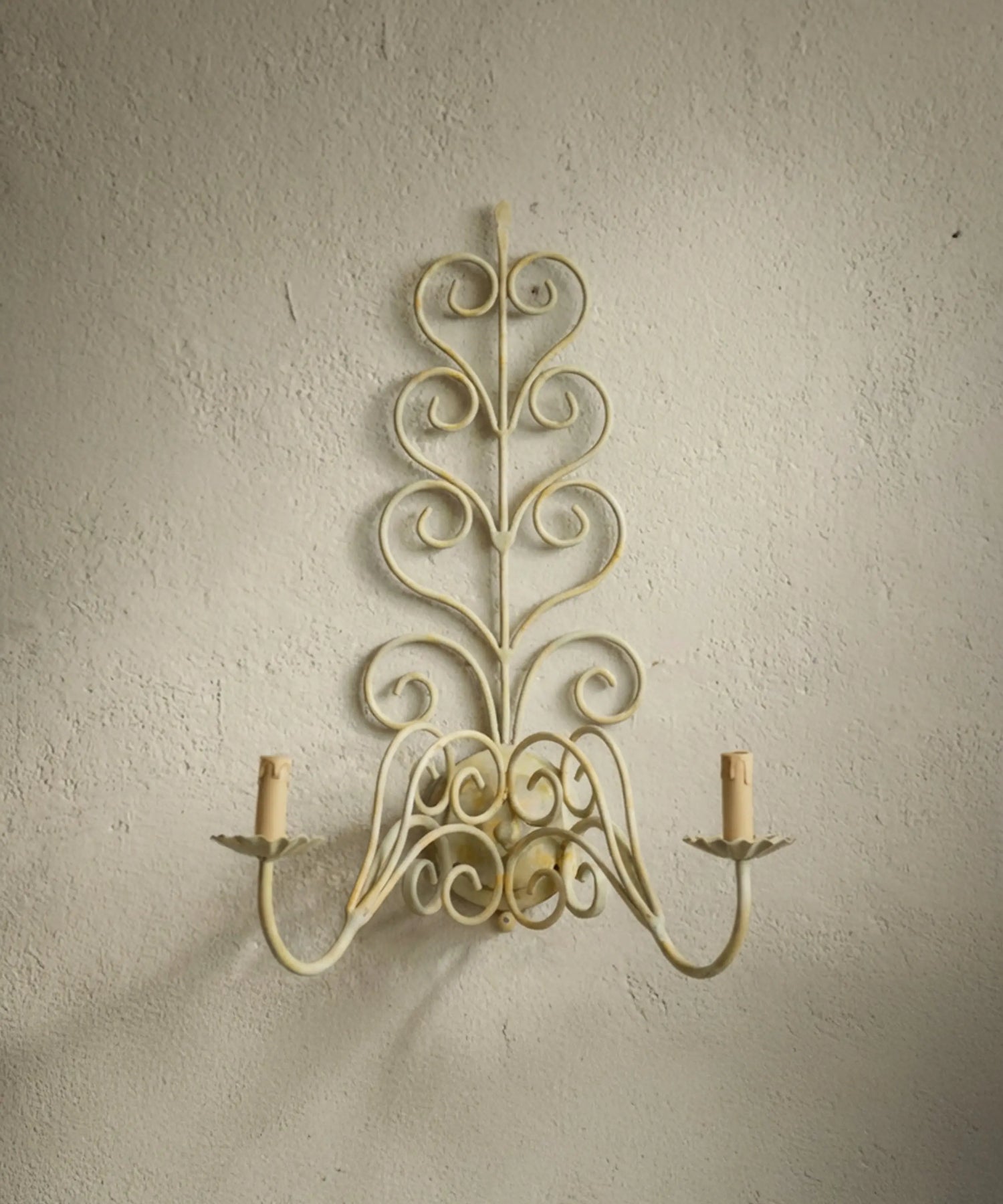Aplique de pared romántico estilo shabby chic con volutas de metal y fundas efecto vela.