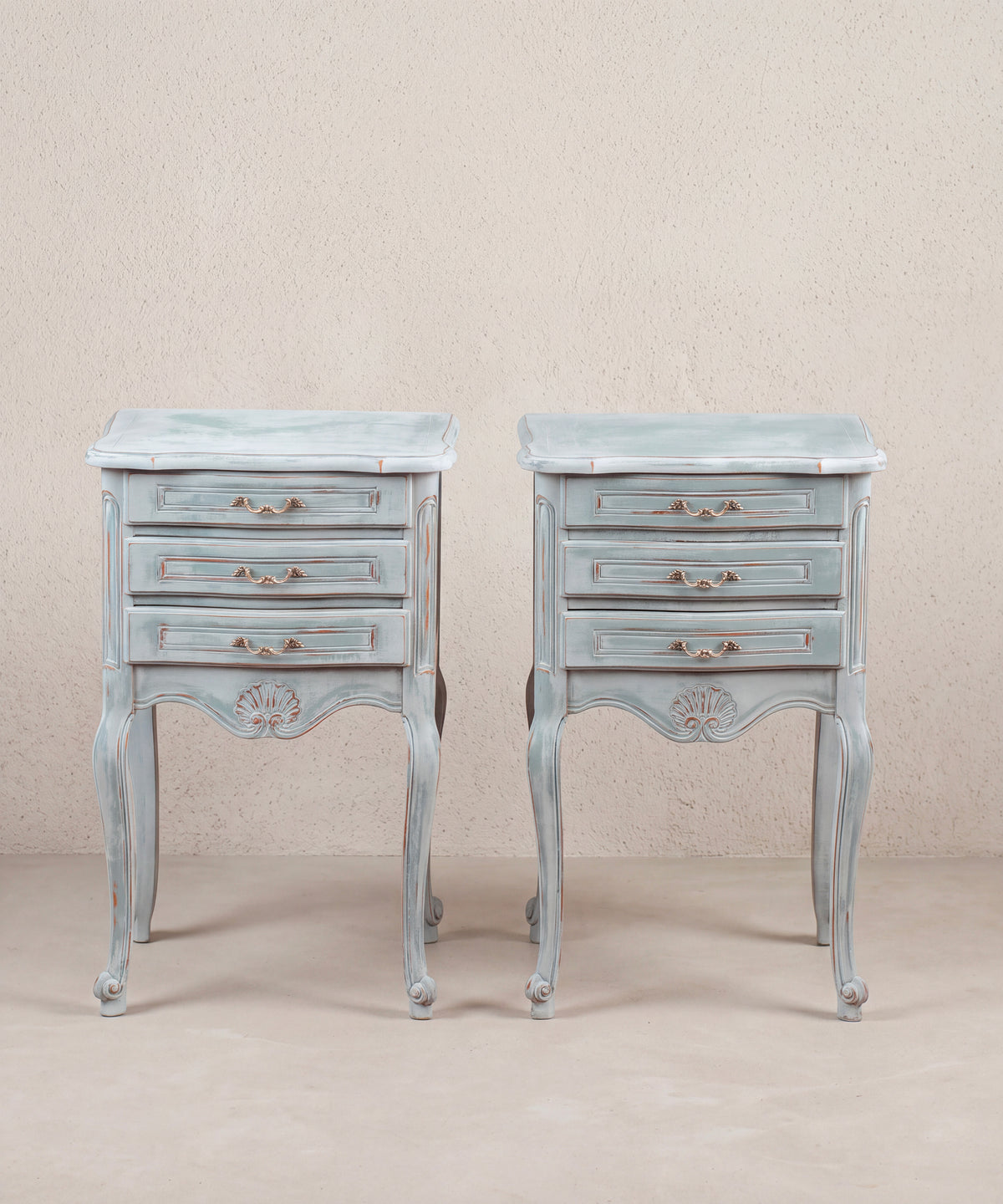 Pareja de mesitas de noche pintadas en azul con tres cajones y concha tallada, vista frontal — Antique Arte y Decoración