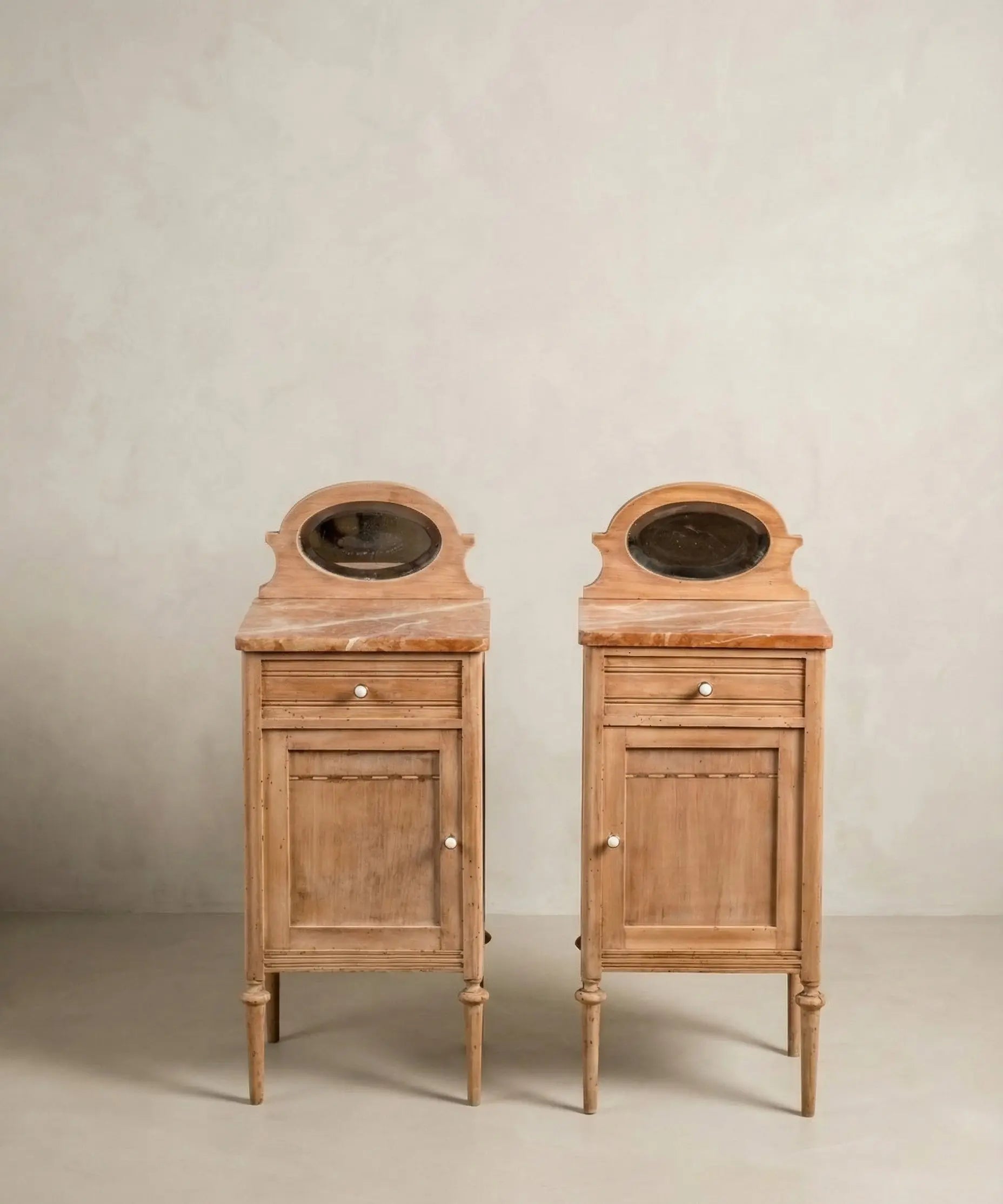 Pareja de mesitas de noche antiguas de madera lavada con encimera de mármol y espejos.